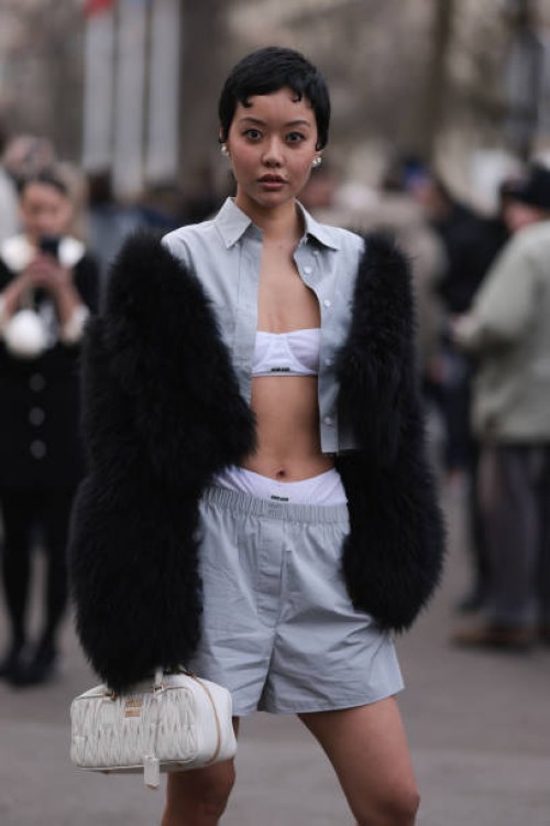 Guest seen wearing Miu Miu white underwear, Miu Miu grey shirt, matching Miu Miu grey shorts, a fur jacket and Miu Miu white handbag outside Miu Miu...