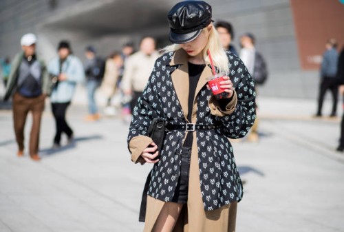 Guest wearing flat cap, belted trench and belted jacket with print is seen at the Hera Seoul Fashion Week 2018 F/W at Dongdaemun Design Plaza on...