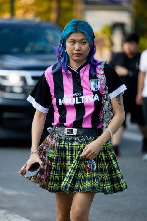 Guest wearing Miu Miu skirt, football jersey outside Collina Strada on September 09, 2022 in New York City.