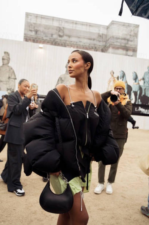Guest wears a black mini dress with green details and black bag outside Off-White during the Womenswear Fall/Winter 2024/2025 as part of Paris...