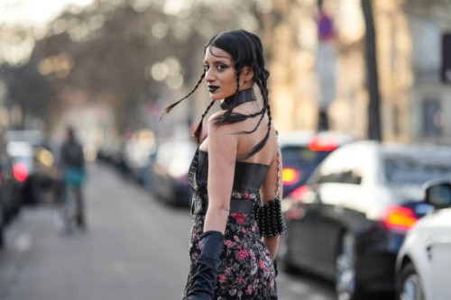 Guest wears a black shiny leather large nailed / studded belted top, a black with embroidered red and pink flower pattern shoulder-off / long dress,...