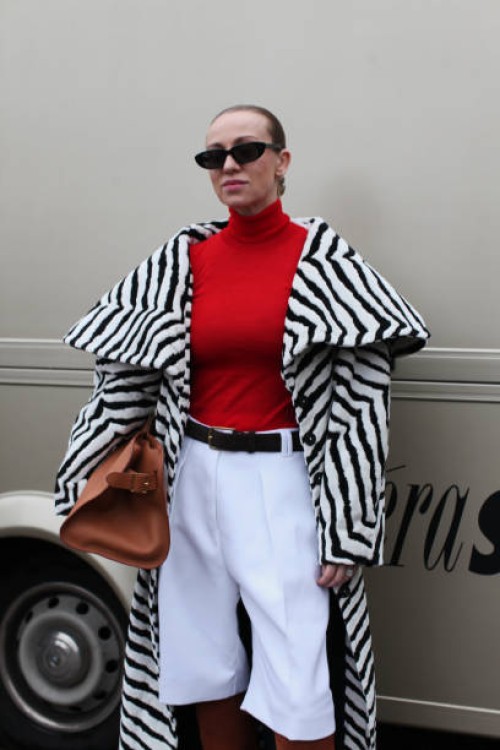 Guest wears a Black & White Animal Print Coat with a Red Polo Neck Jumper at OpéraSport, during the Copenhagen Fashion Week Autumn/Winter 2025 on...