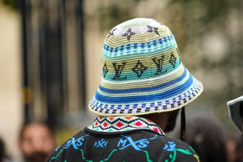 Guest wears a black with neon blue and green embroidered pattern polo shirt, a white / blue / green striped print pattern with embroidered LV black...