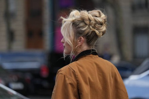Guest wears a brown jacket, earrings, outside Miu Miu, during the Womenswear Spring/Summer 2024 as part of Paris Fashion Week on October 03, 2023 in...