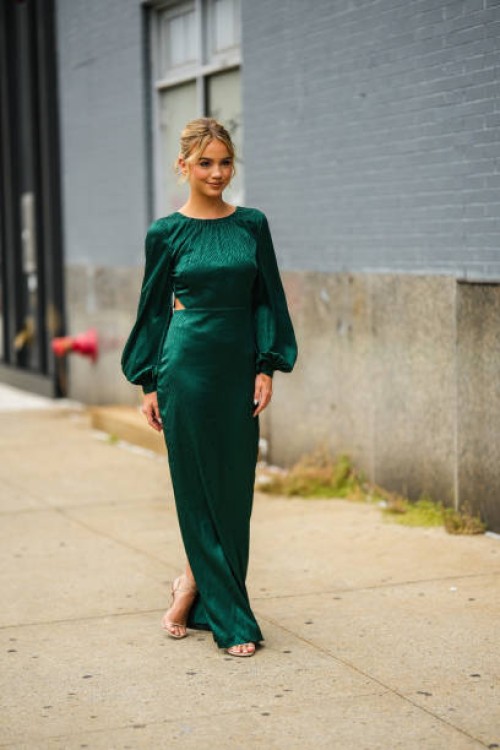 Guest wears a dark green zebra print pattern puffy long sleeves long dress, beige heels sandals, during New York Fashion Week, on September 11, 2022...