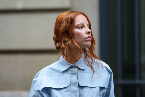 Guest wears a full Patou outfit with a light blue button-up shirt with a structured collar and oversized chest pockets. Hair is styled in loose...