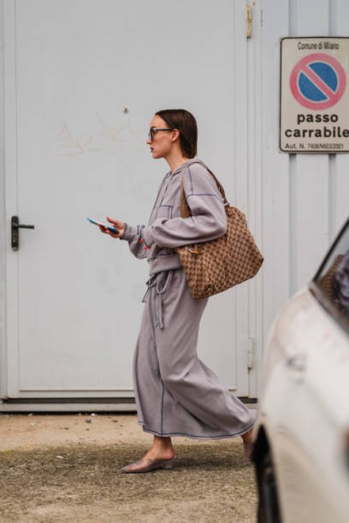 Guest wears a gray wool jacket, brown leather Gucci bag, long gray wool skirt, gray kitten heels, outside Jil Sander, during the Milan Fashion Week...