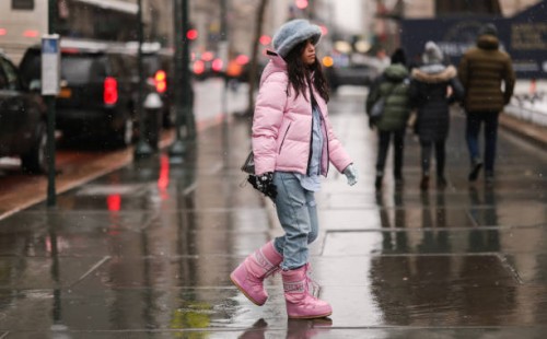 Guest wears a pale gray blue oversized fluffy hat, a pale pink hoodie puffer jacket, a baby blue shirt, blue faded denim large jeans ripped pants, a...