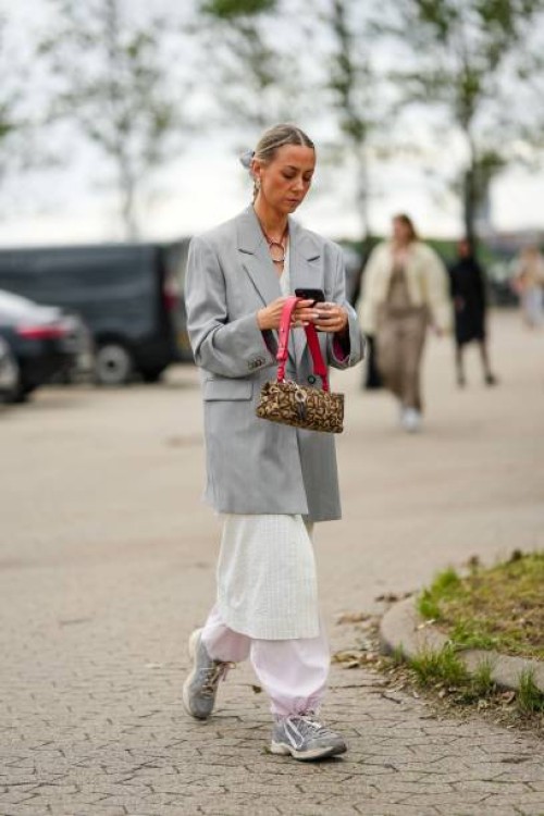 Guest wears a pale gray long blazer jacket, a white striped print pattern long jacket, pale pink puffy pants, gray sneakers, a beige with embroidered...