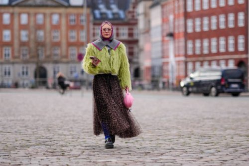 Guest wears a purple and gray ribbed wool balaclava / hood, a yellow / green fluffy oversized jacket , a flowing tulle leopard print pattern gathered...