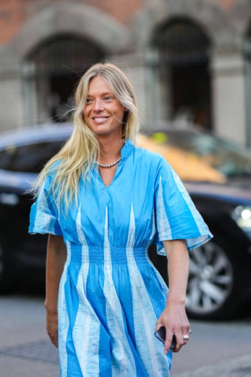 Guest wears a silver pearls necklace, a blue and pale blue print pattern / flared short sleeves / long dress, silver rings, outside Baum und...