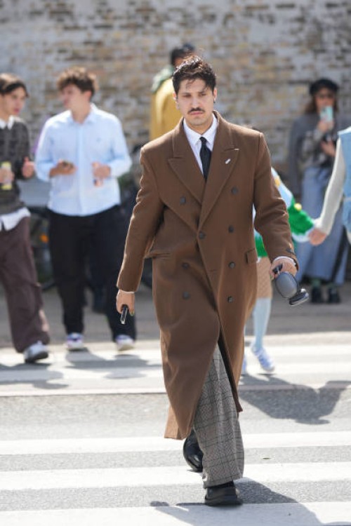 Guest wears a white shirt, a black tie, a dark brown felt wool buttoned long coat, beige checkered print pattern suit pants, black shiny leather...