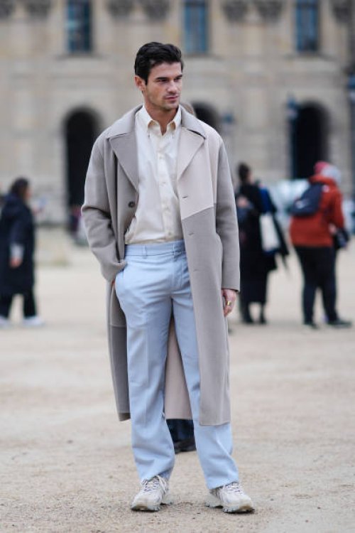 Guest wears a white shirt, a grey and beige trench coat, blue pants, white sneakers, outside Off-White, during the Womenswear Fall/Winter 2024/2025...