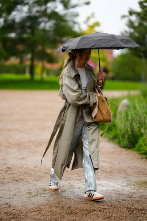 Guest wears a white t-shirt, a pale khaki long trench coat, a camel braided wickers handbag from Marni, silver blue shiny coated canvas large...