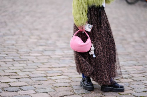 Guest wears a yellow / green fluffy oversized jacket , a flowing tulle leopard print pattern gathered and pleated skirt, blue tights, black leather...