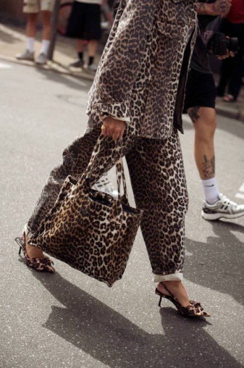 Guest wears animal print pants, animal print jacket and animal print bag outside the Gestuz show during day four of the Copenhagen Fashion Week SS25...