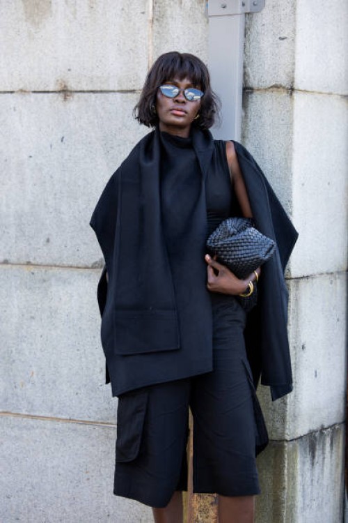 Guest wears black cape, shorts outside Cos during New York Fashion Week on September 10, 2024 in New York City.