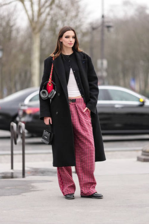 Guest wears black eyeshadow, black cardigan sweater, white top, shiny bright cherry red quilted Chanel leather bag, black double breasted wool coat,...
