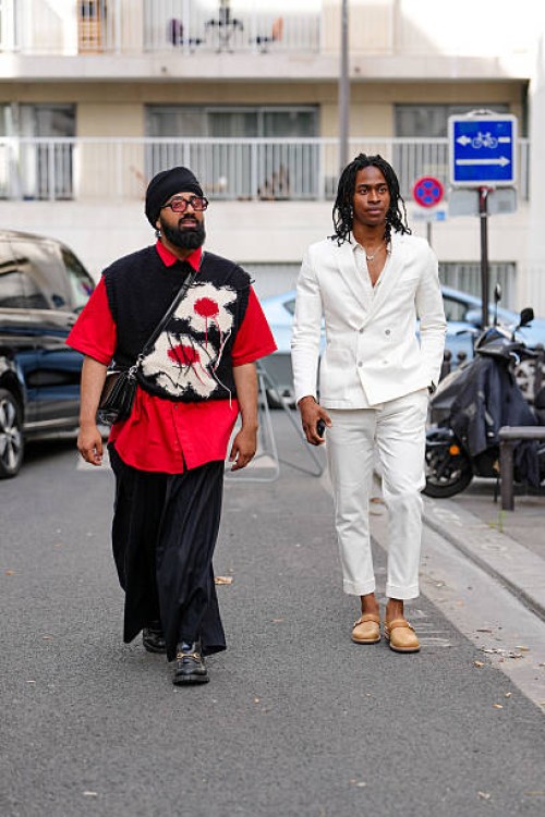 Guest wears black framed sunglasses, head scarf, bright cherry red short sleeve shirt, black knit cream cherry red floral pattern sweater vest, shiny...