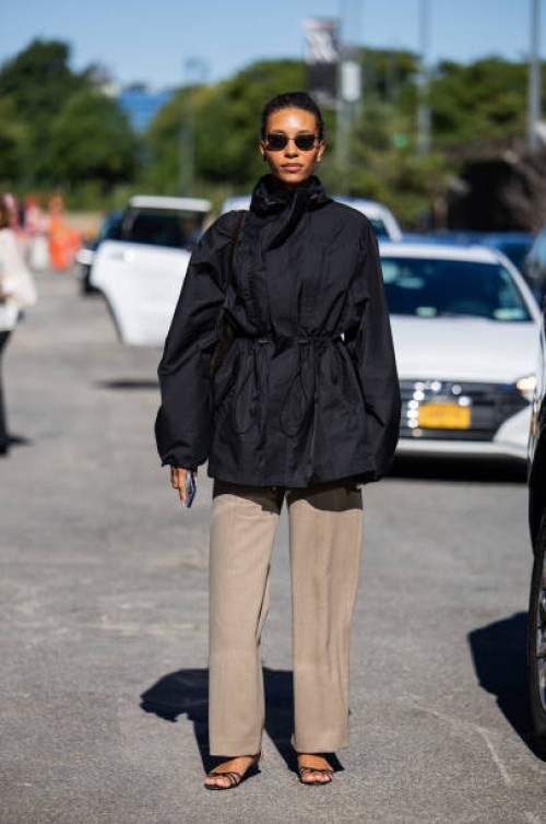 Guest wears black jacket, beige pants outside Ulla Johnson New York Fashion Week on September 08, 2024 in New York City.