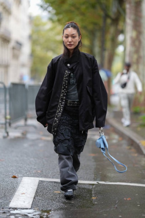 Guest wears black oversized jacket, dark gray t-shirt, black pattern crinkled midi skirt, black loose pants, bright blue leather bag, outside Cecilie...