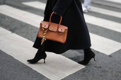 Guest wears black pointed toe heels boots, a shiny dark brown Hermes leather bag, outside Miss Sohee, during the Haute Couture Spring/Summer 2025 on...