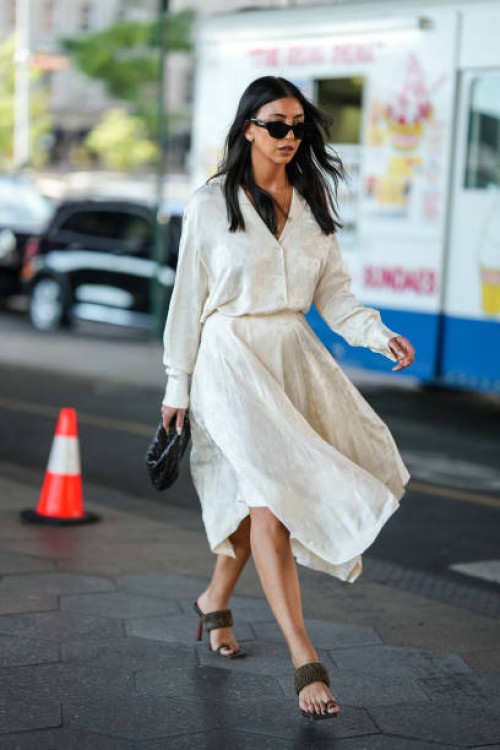 Guest wears black sunglasses, a white latte with embroidered flower pattern silk shirt, a matching white latte with embroidered flower pattern silk...