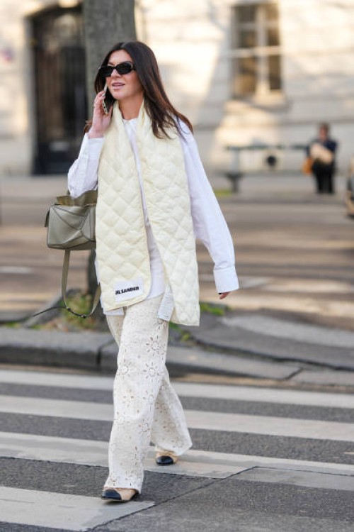 Guest wears black sunglasses, a white shirt, a pale yellow quilted puffy large scarf from Jil Sander, a khaki matte leather Puzzle handbag from...