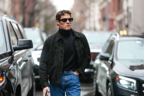 Guest wears black sunglasses, black turtleneck long sleeve shirt, black cropped jacket, navy blue straight fit denim jean pants, outside Todd Snyder,...