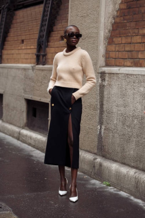 Guest wears blakc long skirt, beige cropped sweater sunglasses and white shoes outside Chloe during the Womenswear Fall/Winter 2024/2025 as part of...
