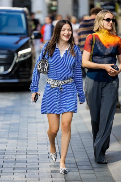Guest wears blue white striped dress, belt, bag outside Kent & Curwen during London Fashion Week September 2024 on September 14, 2024 in London,...