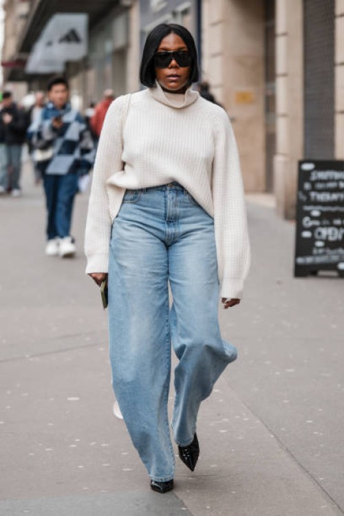 Guest wears cream sweater and baggy jeans, outside Dries Van Noten, during the Womenswear Fall/Winter 2024/2025 as part of Paris Fashion Week on...