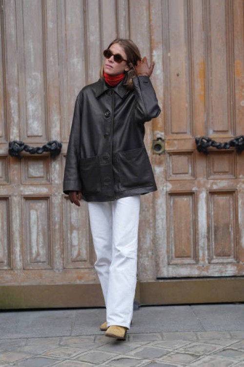 Guest wears dark brown sunglasses, bright red turtle neck long sleeve shirt, shiny black oversized jacket, dark brown leather gloves, white pants,...
