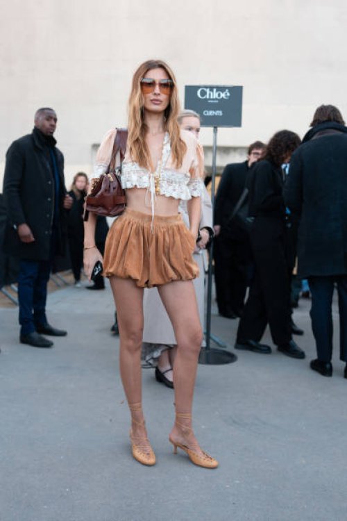Guest wears dark brown sunglasses, gold necklace, white light pink lace cropped Chloe shirt, shiny dark brown Chloe leather bag, light brown high...