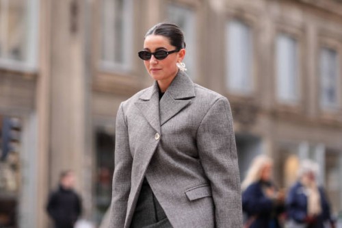 Guest wears earrings, sunglasses, a gray oversized blazer jacket , outside The Garment, during the Copenhagen Fashion Week AW24 on January 31, 2024...