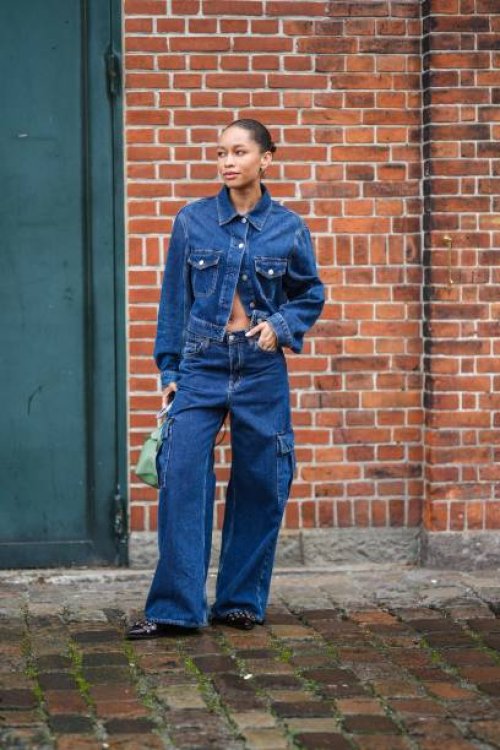 Guest wears gold earrings, a navy blue denim buttoned jacket, matching navy blue denim cargo large pants, a green matte leather handbag, dark brown...