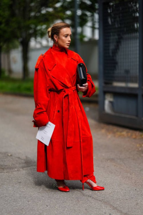 Guest wears gold earrings, bright red turtleneck long sleeve Ferragamo, bright red suede Ferragamo trench coat, bright red tight Ferragamo pants,...