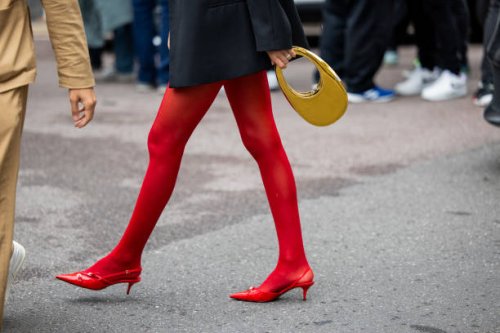 Guest wears golden Coperni bag, red tights outside Philosophy during the Milan Fashion Week - Womenswear Spring/Summer 2024 on September 22, 2023 in...