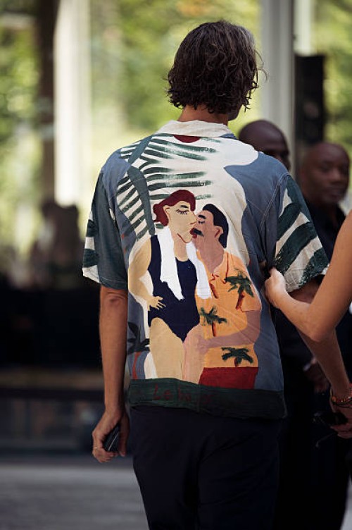 Guest wears graphic shirt and black pants outside Ardazaei show during the Haute Couture Fall/Winter 2025/2026 as part of Paris Fashion Week on July...