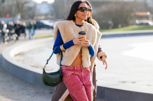 Guest wears green bag, vest, red pants outside Marimekko during the Copenhagen Fashion Week AW24 on February 01, 2024 in Copenhagen, Denmark.