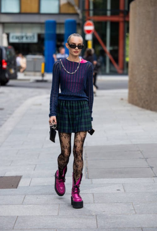Guest wears green checkered skirt outside David Koma during London Fashion Week September 2023 at the on September 16, 2023 in London, England.