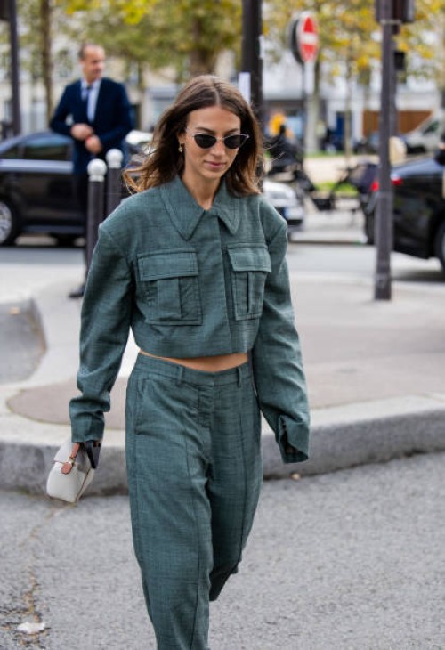 Guest wears green jacket with side pockets, pants outside Stella McCartney during Womenswear Spring/Summer 2025 as part of Paris Fashion Week on...