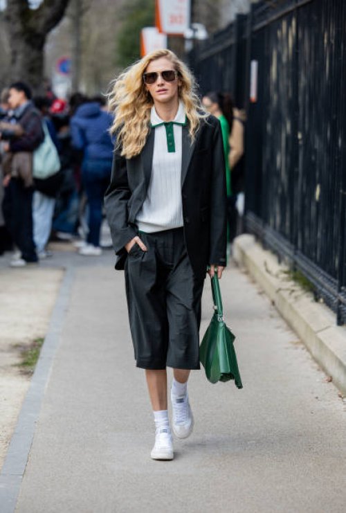 Guest wears green shorts, blazer, bag outside Lacoste during the Womenswear Fall/Winter 2025/2026 as part of Paris Fashion Week on March 09, 2025 in...