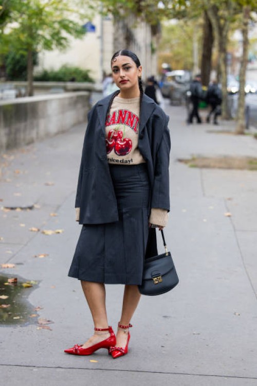 Guest wears grey blazer, skirt, black bag outside Ganni during Womenswear Spring/Summer 2025 as part of Paris Fashion Week on September 24, 2024 in...