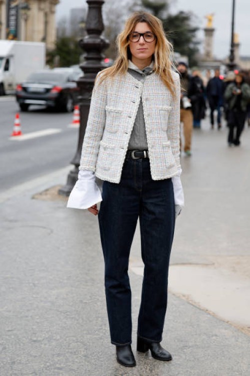 Guest wears grey sweater, dark blue jeans, cream tweed jacket, outside Chanel, during Haute Couture Spring-Summer 2025 as part of Paris Fashion Week...