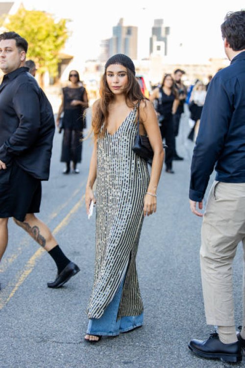 Guest wears head pice, striped dress, denim jeans, heels, bag outside Cos during New York Fashion Week on September 10, 2024 in New York City.