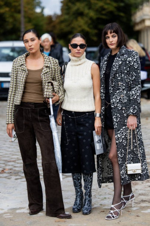 Guest wears jacket, brown pants & Sophia Roe wears sleeveless creme white turtleneck knit, skirt with print, boots & a guest wears grey white black...