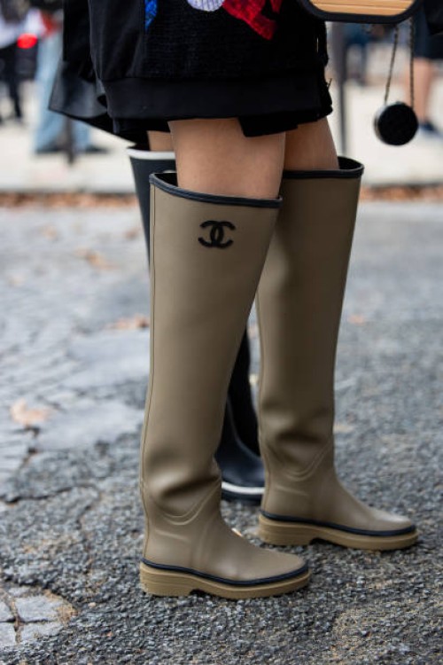 Guest wears khaki gumboots outside Chanel during the Womenswear Spring/Summer 2024 as part of Paris Fashion Week on October 03, 2023 in Paris, France.