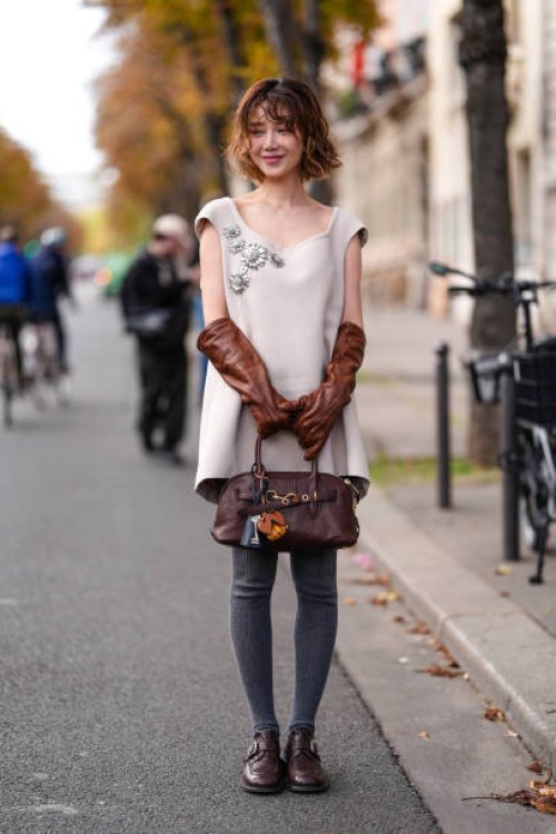 Guest wears light brown beige Miu Miu mini dress with silver embroidered detail, dark brown leather gloves, dark brown Miu Miu leather bag, bag...