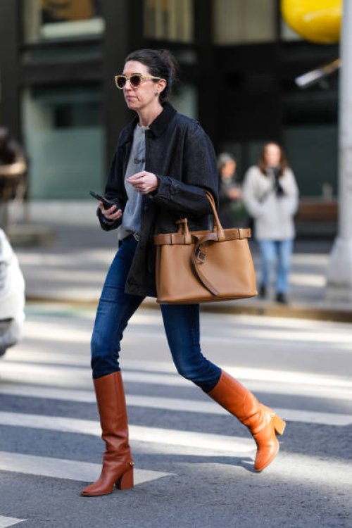 Guest wears light yellow sunglasses, light gray sweater, dark navy blue oversized jacket, light brown caramel belted Prada leather bag, navy blue...